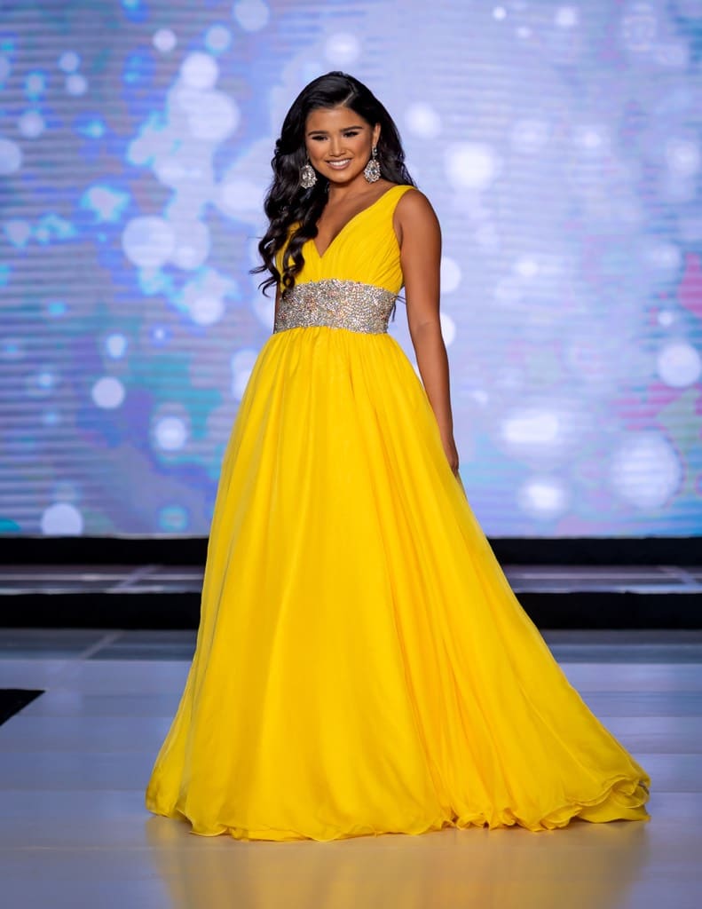 A teenager wearing an evening gown on stage
